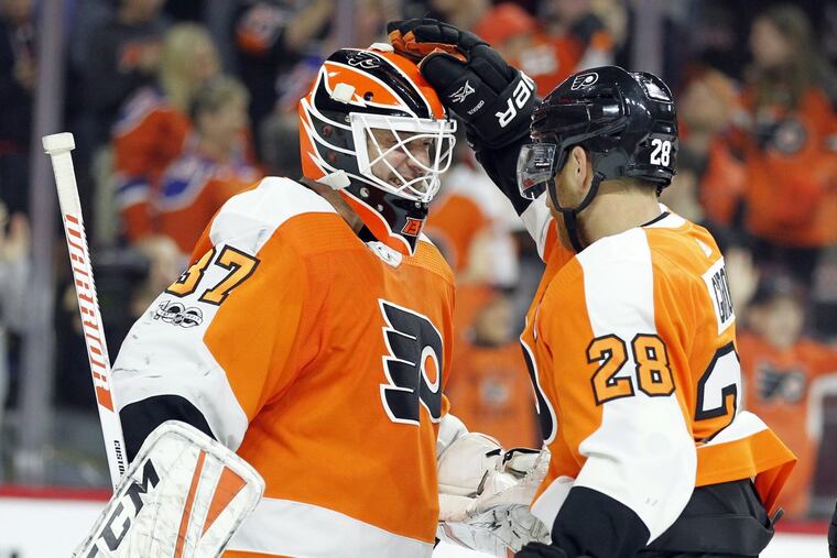 Flyers Brian Elliott (left) and Claude Giroux celebrate the 2-1 win over the Edmonton Oilers on Saturday.