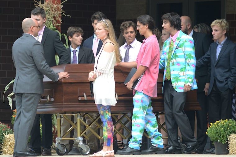 Jenna Burleigh’s older sister, Janelle (center), and younger brothers Jeb (pink shirt) and Jacob (blue jacket) leave St. Maria Goretti Roman Catholic Church.