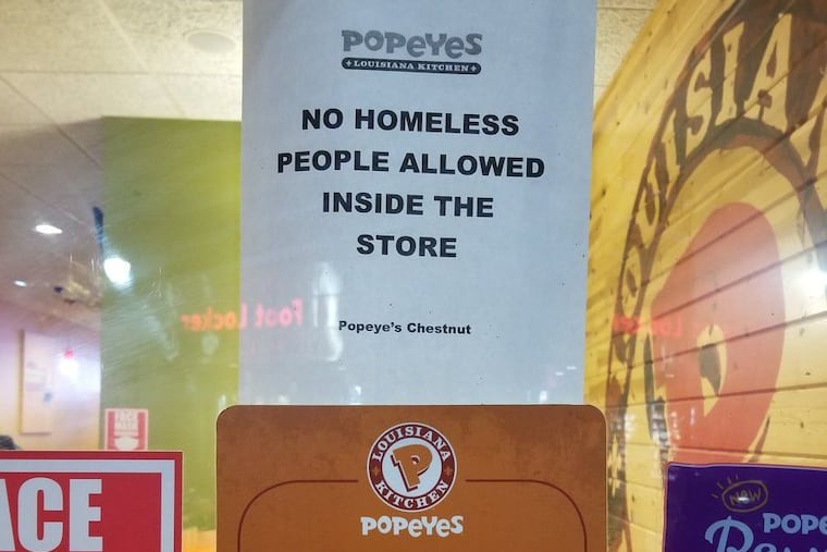 A sign declaring "no homeless people allowed" posted in the front window of the Popeyes on Chestnut Street near 15th Street sparked controversy on social media.