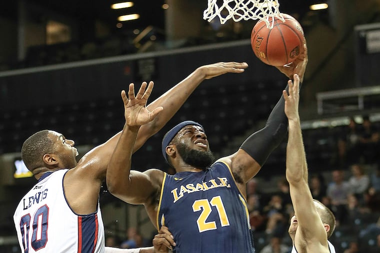 La Salle's Jordan Price takes a shot between Duquesne's Darius Lewis and Micah Mason.