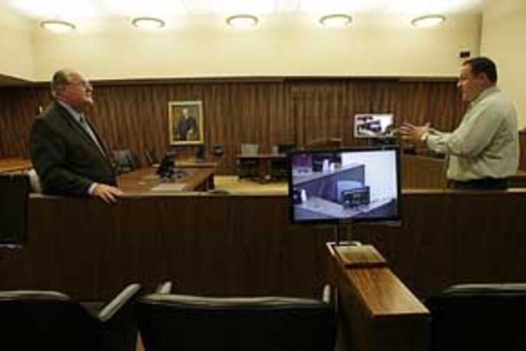 Clerk of court, Michael Kunz (left) and court technology administrator Ed Morrissy, stand near a television monitor in the juror box in Judge John Padova's court room at the James A. Byrne Federal Courthouse on Tuesday, August 10, 2010. (Yong Kim / Staff Photographer)