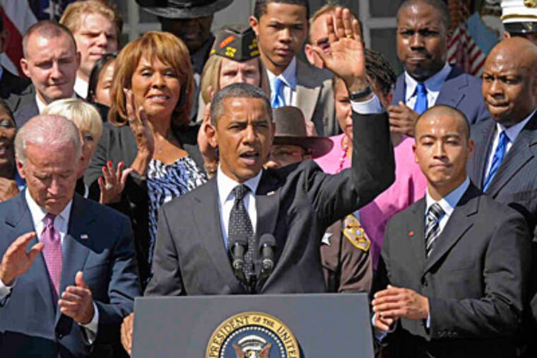 Jason Chuong, a Philadelphia instrumental-music teacher, stands to the president's left during a speech in the Rose Garden on Monday. (SUSAN WALSH / Associated Press)