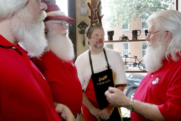 Members of the Amalgamated Order of Real Bearded Santas (all in red), from left to right, Nicholas Trolli, T. Christian Martens and Tim Connaghan, surround Tim Dick. (Renee Sauer / Dispatch photo)