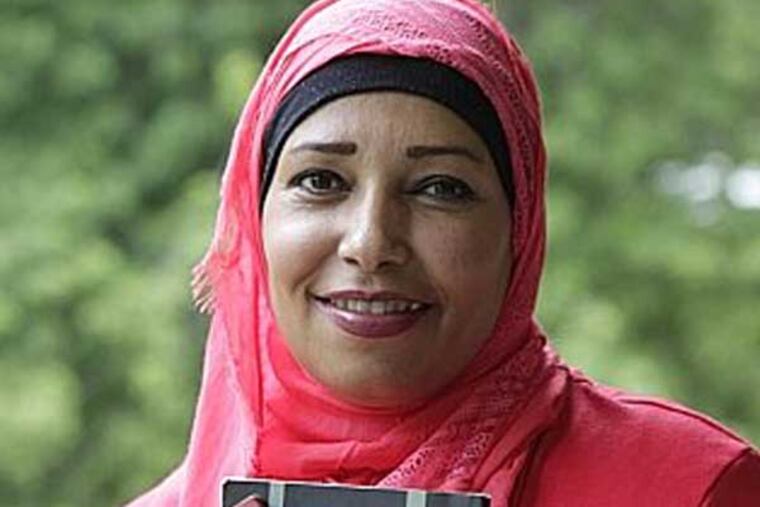 Faleeha Hassan is holding books she wrote at Turnersville, NJ.( AKIRA SUWA / Staff Photographer )