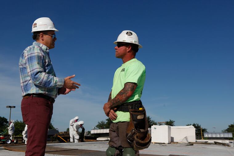 President of EDA Contractors Edward DeAngelis (left) and site foreman Ian Pollini talk on the roof of the Bellmawr Post Office in Bellmawr, NJ, on the morning of Thursday, June 14, 2018. Construction company EDA Contractors is training its roofers and carpenters, some of its most masculine workers, how to be emotionally intelligent. MAGGIE LOESCH / Staff Photographer