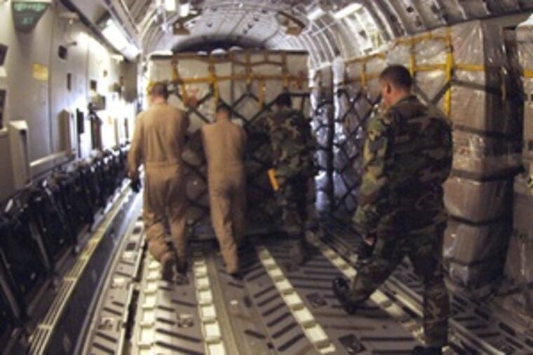Crew members Chris Droegemueller (left), Jason Tripler, Kevin Alexander and Donald Jones, all staff sergeants, move cargo.