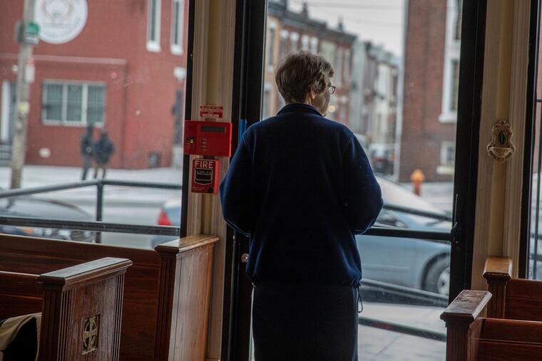 Sister Ann Raymond looks outside the front window of the Mother of Mercy House in Kensington.