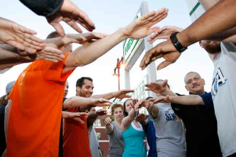 An early-morning run starts with a group cheer at Broad and Bainbridge streets, above. Among the runners are (below), Back on My Feet volunteer Krista Pfeiffer and Ranald Lindsay, who was homeless and jobless before starting the program.