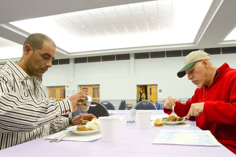 Willy Ulises Soto (left) and Nelson Gonzales eat a dinner served at St. Mary's Church in Cherry Hill as part of the Homeless Hospitality Network involving a number of South Jersey suburban congregations.