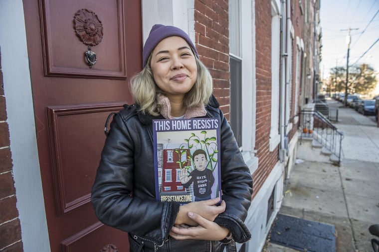 Erika Guadalupe Núñez holds the placard she created for South Philadelphia households to display to promote solidarity in the wake of ICE raids.