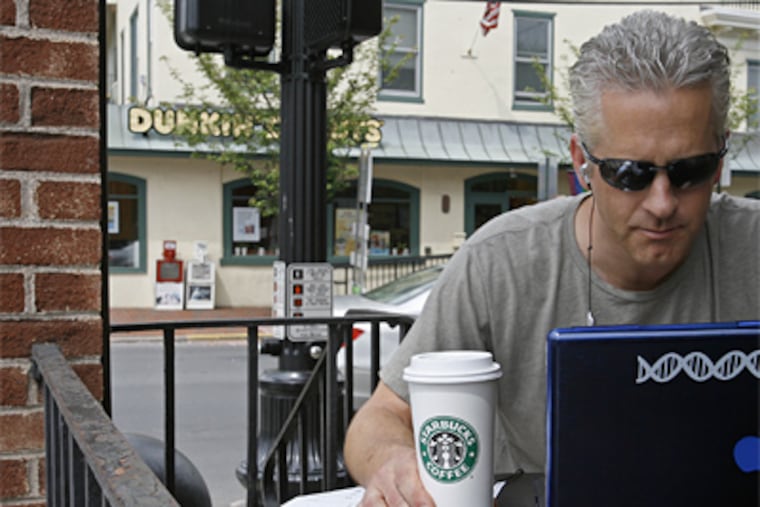 Jon Berndt drinks Starbucks coffee while working on his computer at a corner Starbucks that is across the street from a new Dunkin Donuts. (Michael S. Wirtz / Staff Photographer)