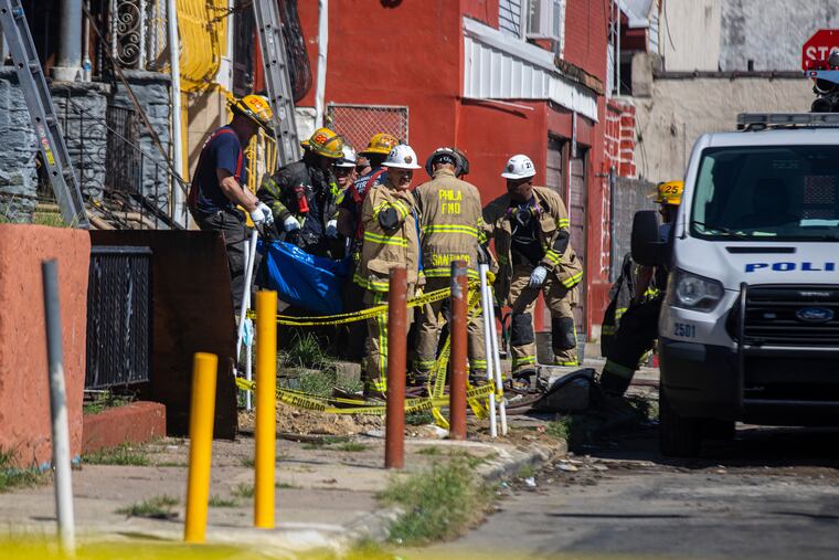 Philadelphia firefighters remove bodies from a home in Kensington where four people died in a fire Saturday morning.