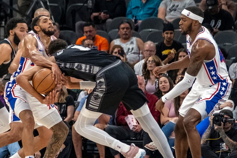 Spurs center Victor Wembanyama is fouled as he gets tangled up with 76ers guard Cameron Payne.
