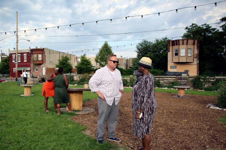 Pop-Up owner John Longacre with neighbor Florence Dixon at the beer garden in Point Breeze. Longacre is in compliance with the law, so what’s with the L&I infractions? (JOSEPH KACZMAREK / FOR THE DAILY NEWS)