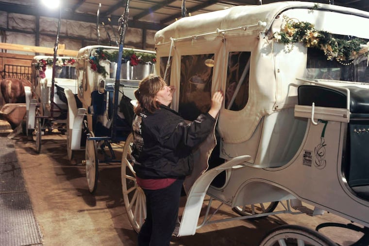 Eleanor Forstater closes a carriage stored in the 76 Carriage Co.'s stables in Northern Liberties in 2018. In January 2023, the company cleared out its stables, but it's unclear if horse-drawn rides will continue.