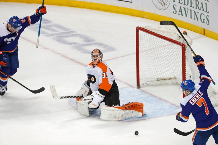 New York Islanders left wing Anders Lee (27) and Islanders right wing Jordan Eberle (7) react as Philadelphia Flyers goaltender Brian Elliott (37) watches the puck roll out of the crease after Islanders defenseman Ryan Pulock (not shown) scored the go-ahead goal during the third period of an NHL hockey game against the Flyers, Tuesday, Feb. 11, 2020, in New York. The Islanders defeated the Flyers 5-3. (AP Photo/Kathy Willens)