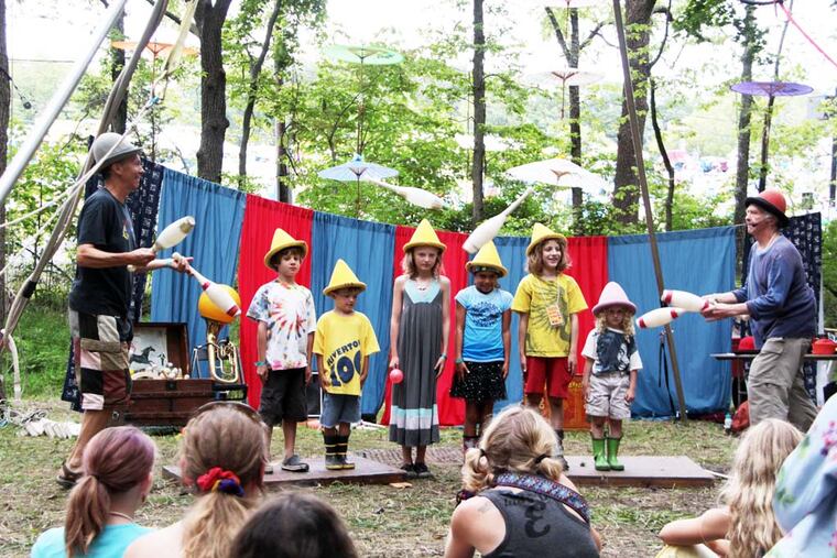Children from the audience help out the Give and Take Jugglers at the 51st Philadelphia Folk Festival. The Dulcimer Grove section of the festival offers shade for the adults and fun for the kids.