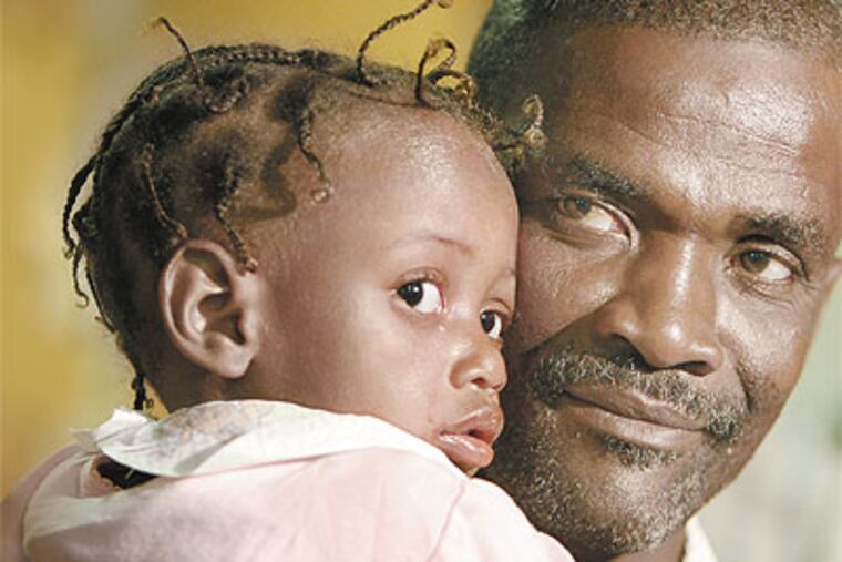 Josue Felime holds daughter Mirlande after a news conference at Abington Memorial Hospital. (David Maialetti / Staff Photographer)