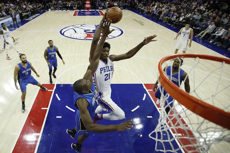 Sixers' Joel Embiid attempts dunk on Magic's Bismack Biyombo during the first half on Friday night.