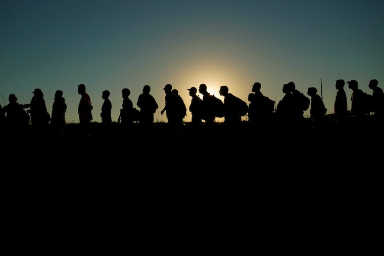 Migrants who crossed the Rio Grande and entered the U.S. from Mexico are lined up for processing by U.S. Customs and Border Protection on Sept. 23, 2023, in Eagle Pass, Texas.