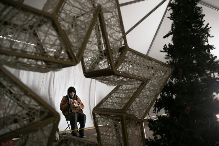 Joe Marks eats his free meal provided by Prevention Point Philadelphia at Ruth and Clearfield Streets in Kensington on Thursday. A hot buffet-style meal will be provided by Catering by Design underneath a warming tent, with decorations from Hoffman Design and the Pennsylvania Horticultural Society, on Christmas Day.
