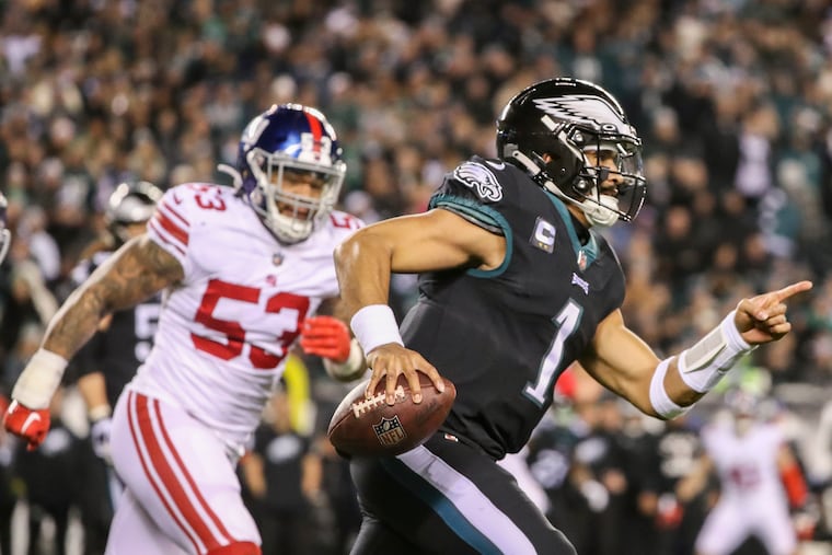 Philadelphia Eagles quarterback Jalen Hurts points as he runs for a first down during the Birds' regular season finale against the New York Giants.