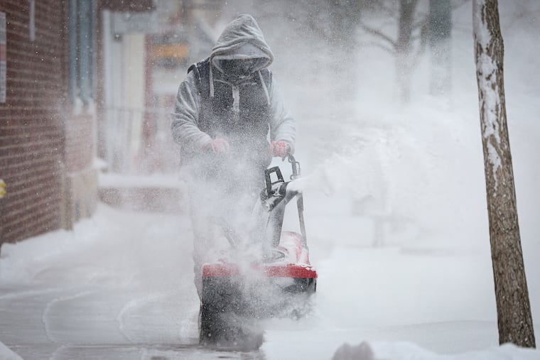 Israel DeJesus uses a snowblower to clear a sidewalk on Church Street in West Chester on Sunday.
