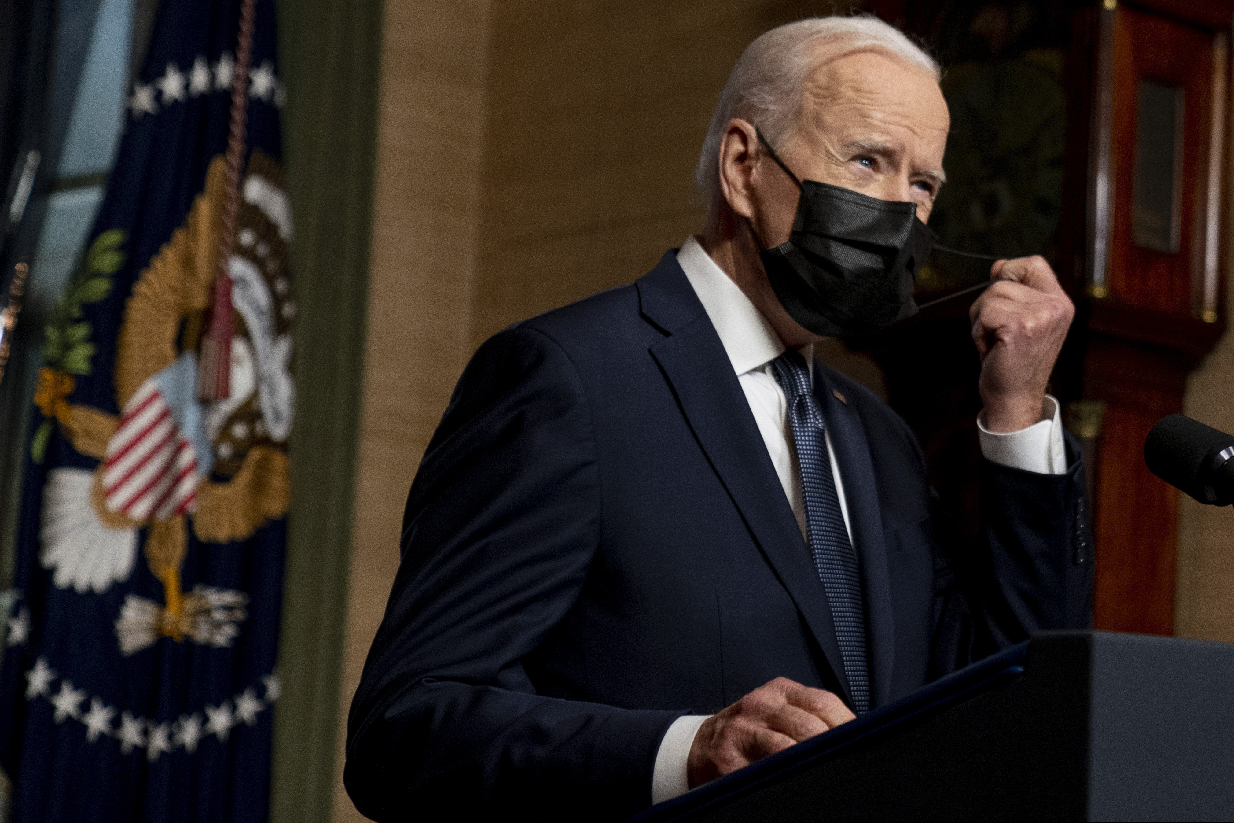 President Joe Biden removes his mask to speak at a news conference in April at the White House.