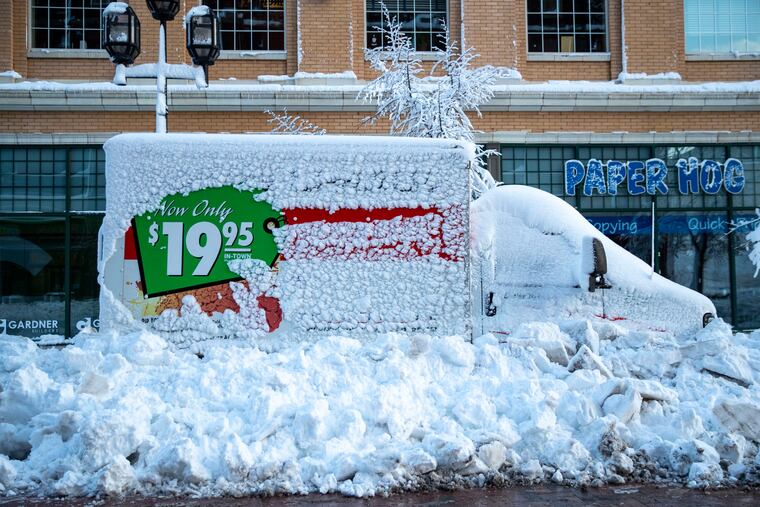 A U-Haul truck sits snowed in by plows on First Street in downtown Duluth, Minn., on Sunday, Dec. 1, 2019.