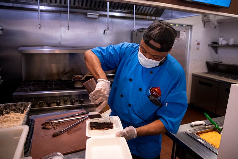 Sean Green, owner of BBQ Unlimited, works on a customer's order at his restaurant in Willow Grove Park's food court.