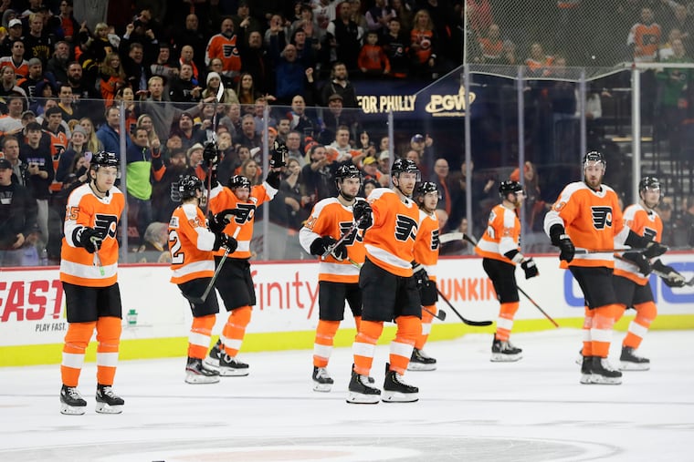 Flyers players point to the puck after Boston Bruins left winger Brad Marchand missed it during a shootout attempt on Monday. It was one of the more bizarre endings to a game you'll ever see.