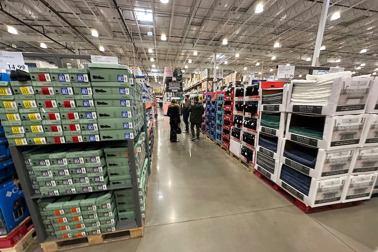 Shoppers make their way down an aisle lined with clothing and shoes in a Costco warehouse Thursday, Jan. 23, 2025, in Sheridan, Colo.