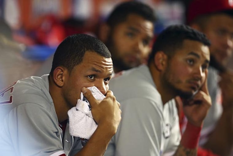 Philadelphia Phillies' Cesar Hernandez, left, watches the action during the seventh inning of a baseball game after Miami Marlins' Casey McGehee drove two runs home in Miami, Thursday, Sept. 25, 2014. The Marlins won 6-4. (J Pat Carter/AP)
