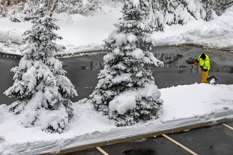 A plowing contractor shovels edges of a parking lot along Rt. 70 in Cherry Hill Monday Feb. 23, 2026.
