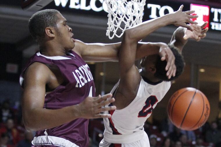 Eric Dixon (left) of Abington blocks a shot by Ish Horn of Plymouth Whitemarsh in February.