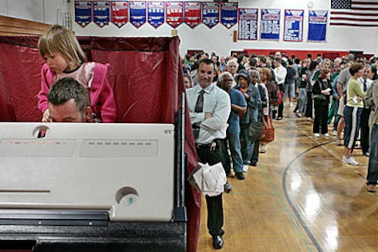1 1/2 yr old Cali Fisler of Washington Township watches dad Keith Fisler vote at the 9-10 gym at Washington Township High School. ( Elizabeth Robertson / Staff )