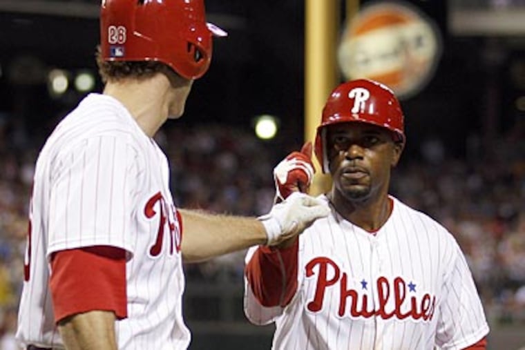 Jimmy Rollins celebrates his fifth-inning run against the Marlins with Chase Utley. (Yong Kim/Staff Photographer)