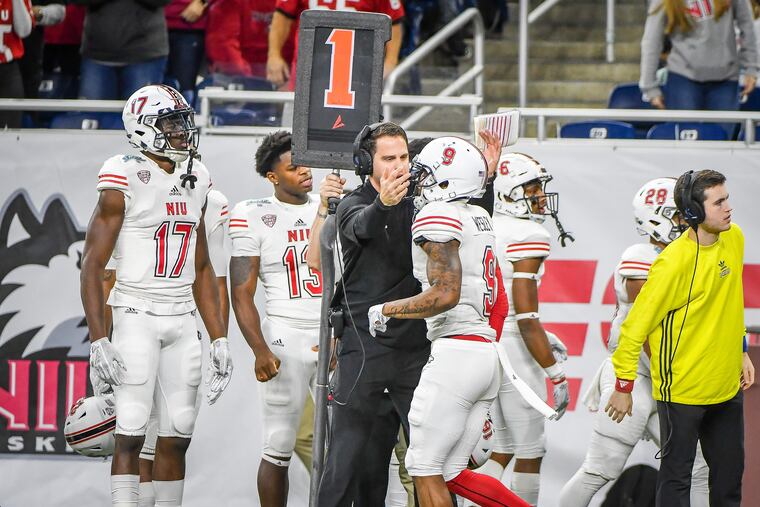 Northern Illinois offensive coordinator Mike Uremovich (middle) congratulating one of his players this past season.