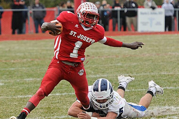 St. Joseph quarterback Salaam Horne escapes the grasp of Hammonton
linebacker Rosu Dylan. (Ron Tarver/Staff Photographer)