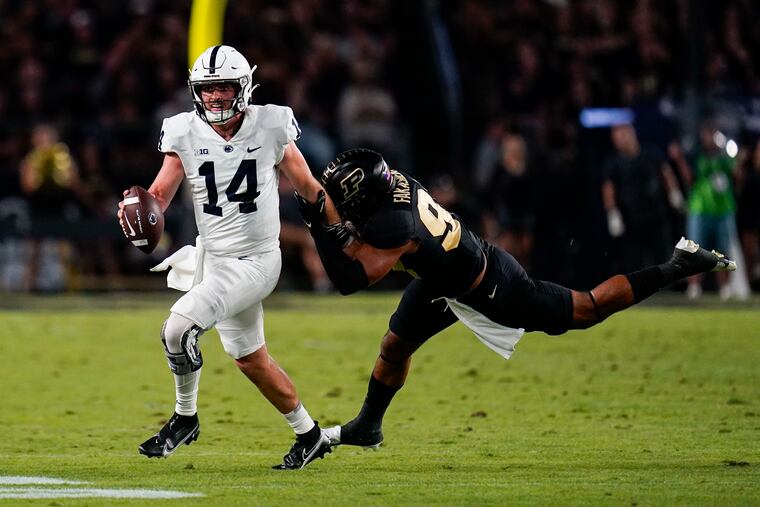 Penn State quarterback Sean Clifford getting chased by Purdue linebacker Semisi Fakasiieiki.