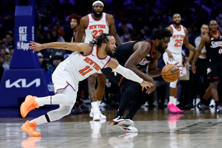 New York Knicks guard Jalen Brunson reaches after the basketball against Sixers center Joel Embiid in the third quarter of Saturday's nailbiter of a game in Philly.