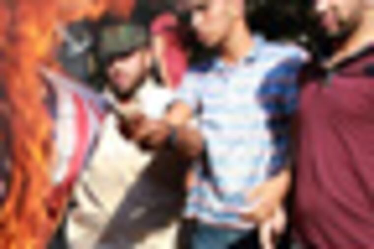 Palestinians burn a U.S. flag during a protest against the movie, "Innocence of Muslims," near the United Nations office in Gaza City, Wednesday, Sept. 12, 2012. Muslim anger over perceived Western insults to Islam has exploded several times, most recently in Tuesday's attacks against U.S. diplomatic posts in the Middle East in which U.S. ambassador to Libya Chris Stevens and three other Americans were killed. (AP Photo/Adel Hana)