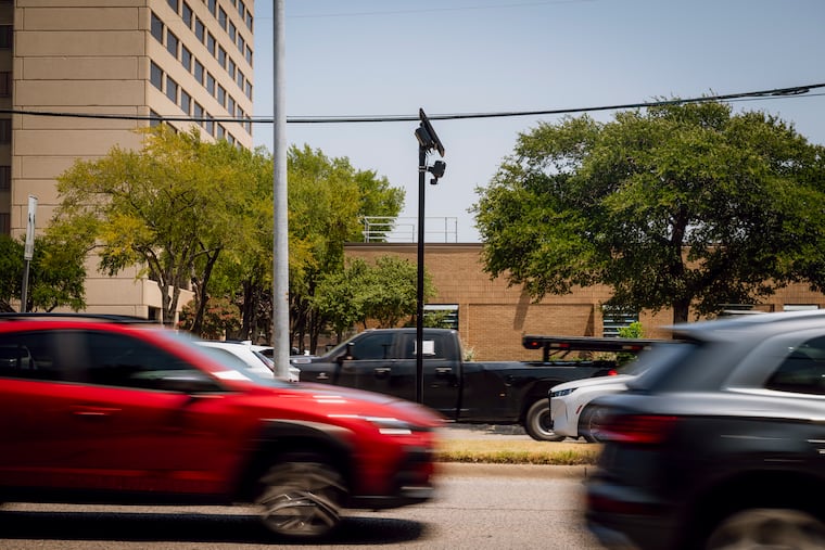 Vehicles drive past a Flock Safety automated license plate-reading camera in Farmers Branch, Texas, Aug. 3, 2026. Flock cameras use algorithms to read letters and numbers on license plates.