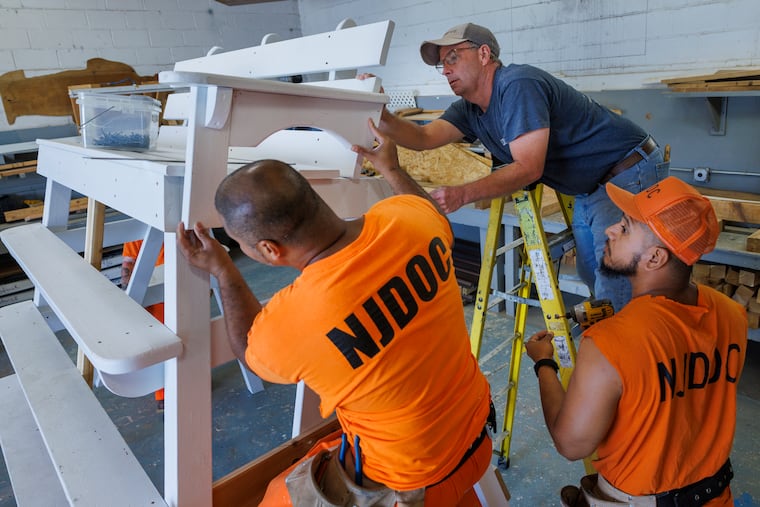 At top right is Mark Andres, carpentry instructor working with “Incarcerated Persons” William Beam and Henry Hernandez. (hat) These men are incarcerated at Bayside State Prison in Leesburg, NJ and participating in the Deptcor Carpentry Shop Vocational Training Program. These men are working on a lifeguard stand to be used on New Jersey beaches. Photograph taken on Monday, June 5, 2023.