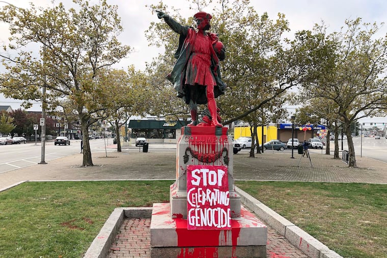 A sign reading "stop celebrating genocide" sits at the base of a statue of Christopher Columbus on Monday, Oct. 14, 2019, in Providence, R.I., after it was vandalized with red paint on the day named to honor him as one of the first Europeans to reach the New World. The statue has been the target of vandals on Columbus Day in the past.