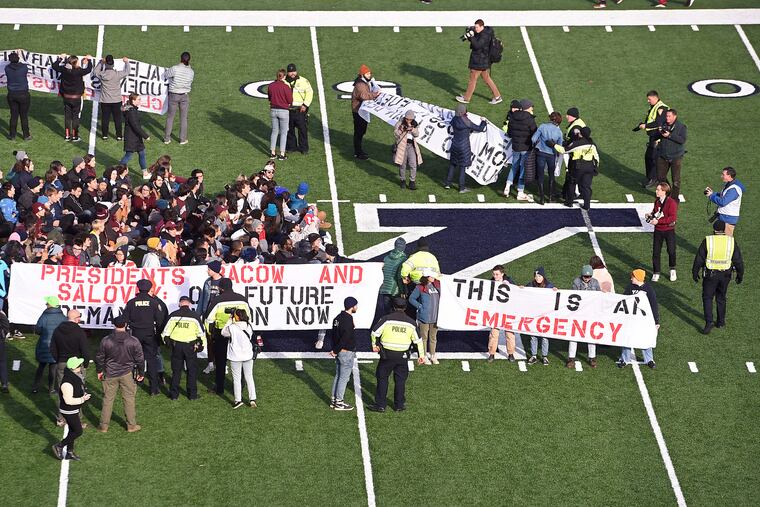 Demonstrators stage a climate change protest at the Yale Bowl delaying the start of the second half of an NCAA college football game between Harvard and Yale Saturday, Nov. 23, 2019, in in New Haven, Conn.