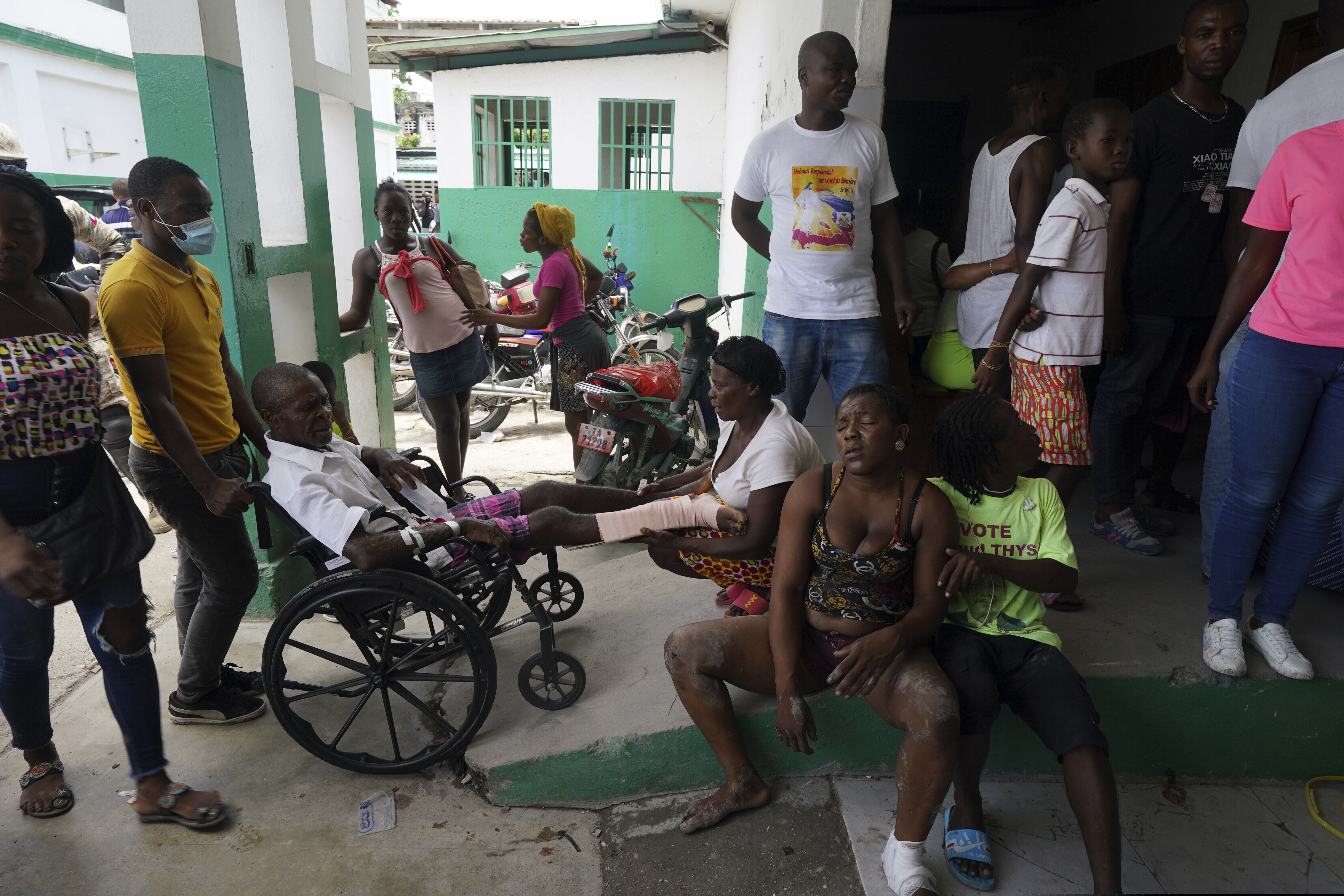 People injured in a car accident, sitting right, wait with others injured during the earthquake for X-rays at the General Hospital in Les Cayes, Haiti, on Wednesday.
