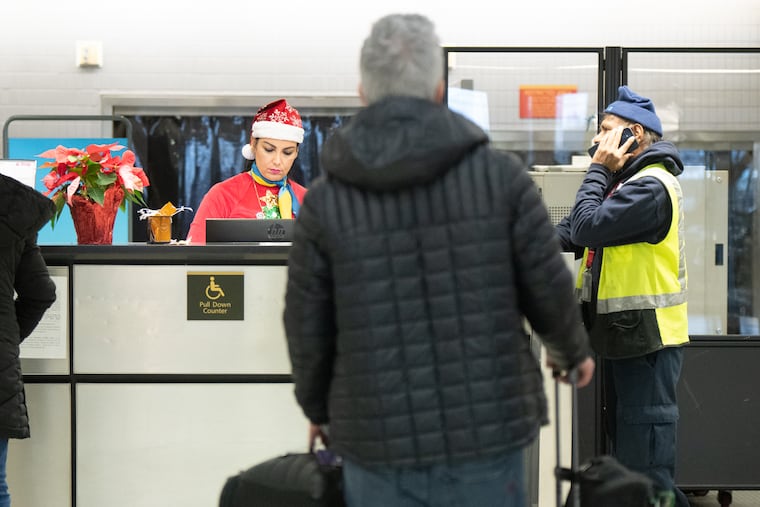 A staff person at Discover Airlines wears a Santa hat at the Philadelphia International Airport on Christmas Eve in 2024.