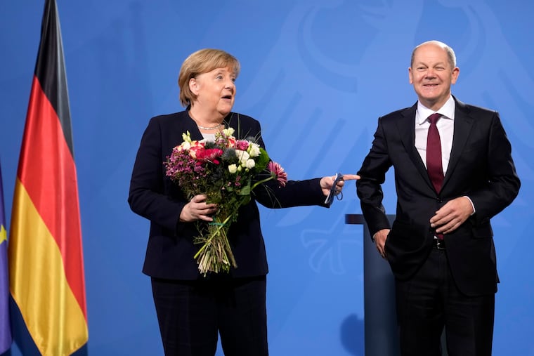 New elected German Chancellor Olaf Scholz, right, has given flowers to former Chancellor Angela Merkel during a handover ceremony in the chancellery in Berlin, Wednesday, Dec. 8, 2021. (Photo/Markus Schreiber)