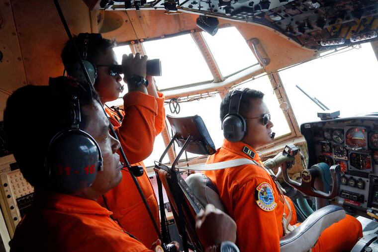 Searchers scan the horizon from an Indonesian air force plane flying over the Karimata Strait. The AirAsia jet they were looking for was flying from Surabaya, Indonesia, to Singapore when it disappeared Sunday.
